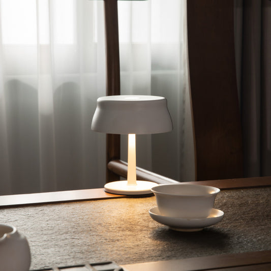 Luna Mini opladelig bordlampe i hvid med varmt lys på køkkenbord i moderne nordisk hjem