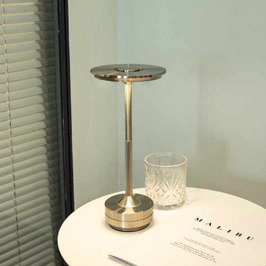 Nordika Classic opladelig bordlampe i sølv placeret på rundt sidebord med moderne nordisk indretning