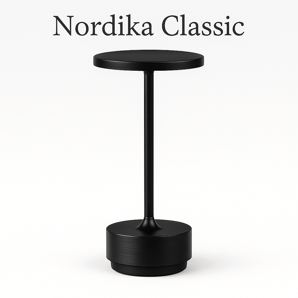 Nordika Classic bordlampe i sort aluminium – trådløs og opladelig med rund top og detaljeret fod. Vist på hvid baggrund.