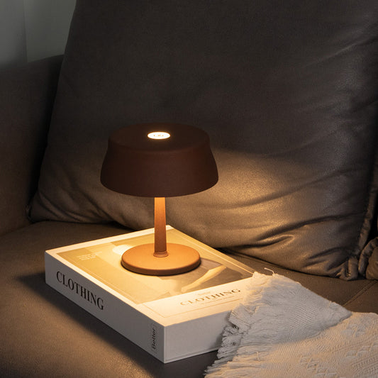 Luna Mini opladelig bordlampe i brun med varmt hyggelys på sofabord i moderne stue