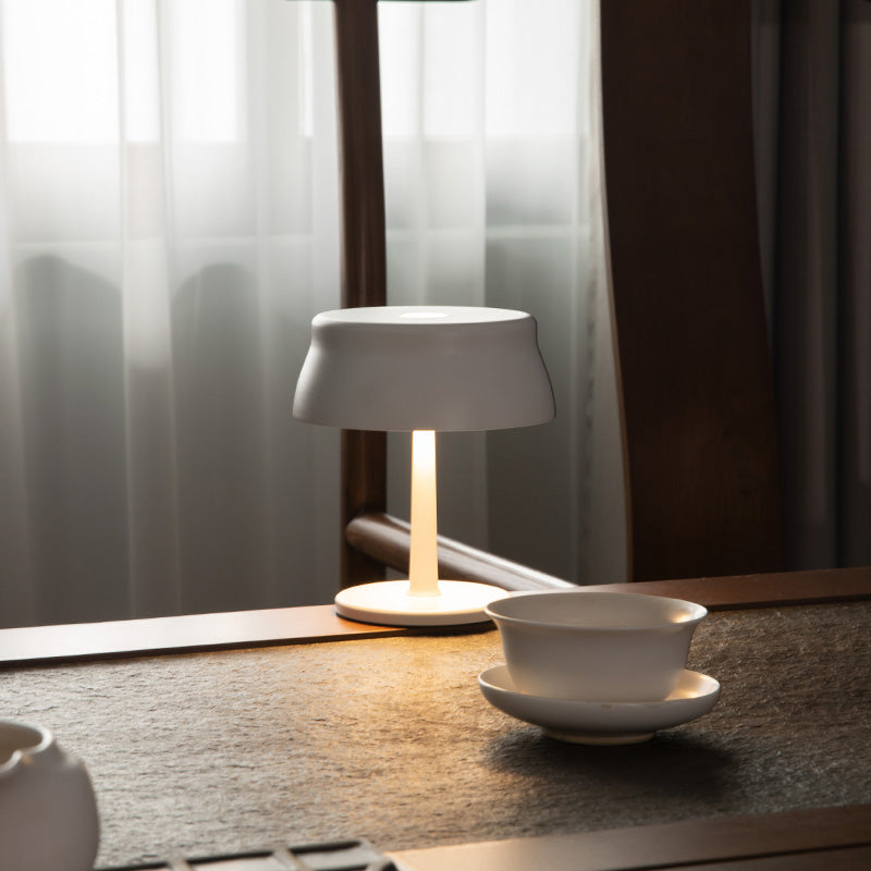 Luna Mini opladelig bordlampe i hvid med varmt lys på køkkenbord i moderne nordisk hjem