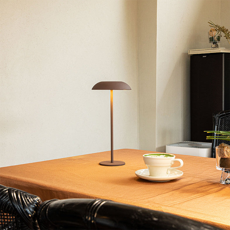 Luna opladelig bordlampe i brun med varmt hyggelys på bord i moderne café og nordisk indretning