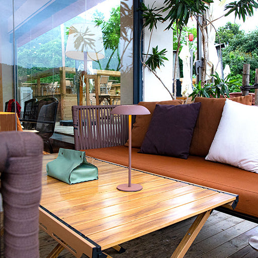 Luna opladelig bordlampe i brun med varmt hyggelys på loungebord i moderne terrassemiljø