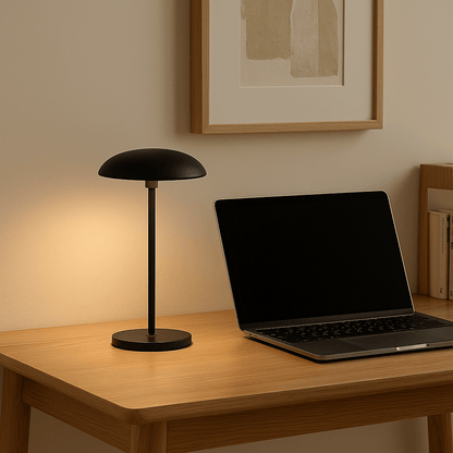 Sort Luna bordlampe på lyst skrivebord med bærbar computer, ideel til både arbejde og hyggebelysning.