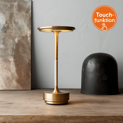 Guld Nordika Classic lampe på rustik træbord med ikon for touchfunktion.