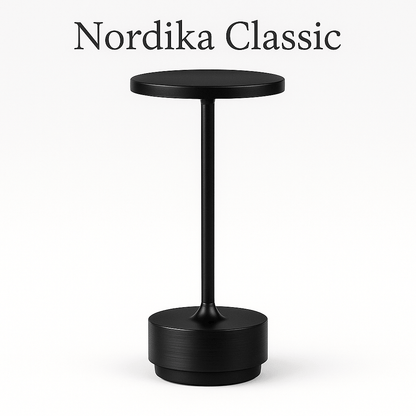 Nordika Classic bordlampe i sort aluminium – trådløs og opladelig med rund top og detaljeret fod. Vist på hvid baggrund.