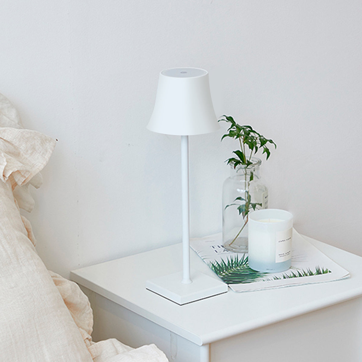 Sigtuna opladelig bordlampe i hvid på minimalistisk natbord med nordisk indretning
